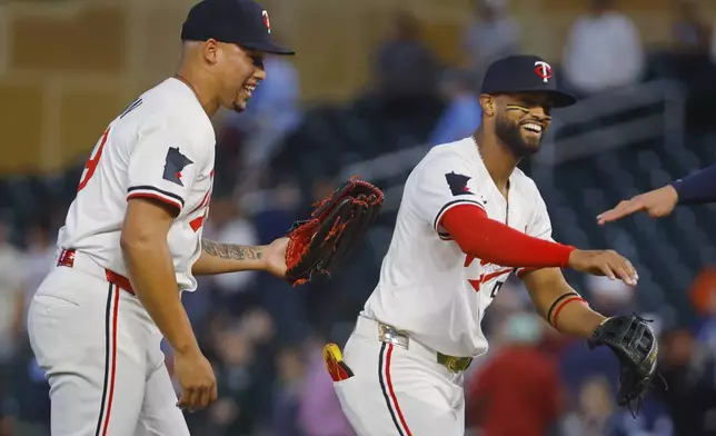Minnesota Twins' Jhoan Duran, left, and Willi Castro celebrate the team's win against the Seattle Mariners after a baseball game Wednesday, June 25, 2025, in Minneapolis. (AP Photo/Bruce Kluckhohn)