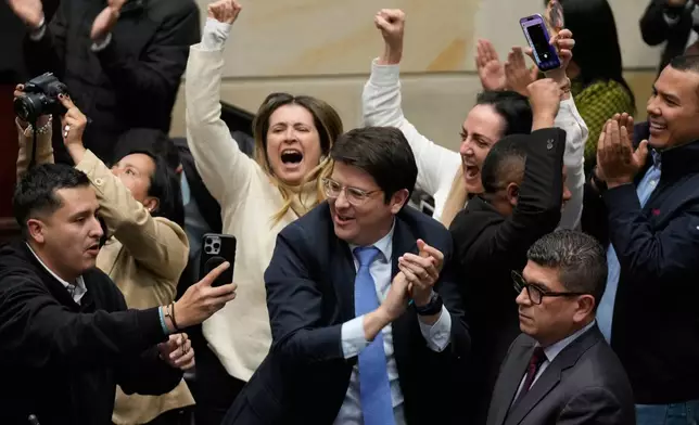 FILE - Miguel Uribe Turbay, center in blue tie, a Colombian senator and presidential candidate for the right-wing Centro Democrático party, celebrates after voting against a labor reform referendum proposed by the government, in Bogota, Colombia, May 14, 2025. (AP Photo/Fernando Vergara, File)