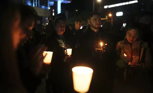 People hold candles during a vigil outside the Santa Fe hospital where Colombian senator and presidential candidate Miguel Uribe Turbay is being treated after he was shot during a campaign rally in Bogota, Colombia, Saturday, June 7, 2025. (AP Photo/Ivan Valencia)
