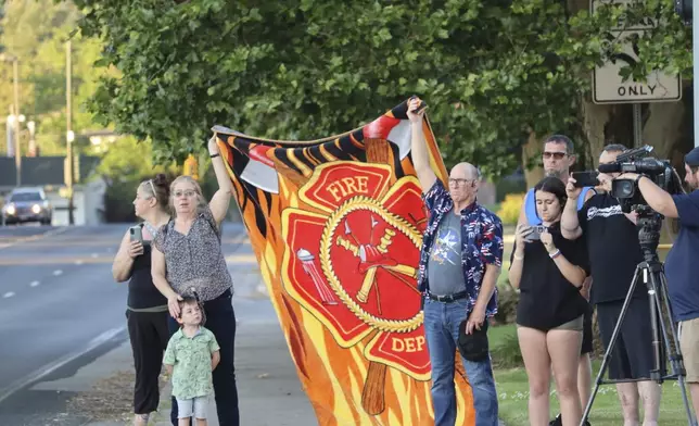 A procession from Kootenai Health headed to Spokane after a few firefighters were killed Sunday, June 29, 2025, when they were ambushed by sniper fire while responding to a blaze in a northern Idaho mountain community, in Coeur d’Alene, Idaho. (Bill Buley/Coeur D'Alene Press via AP)
