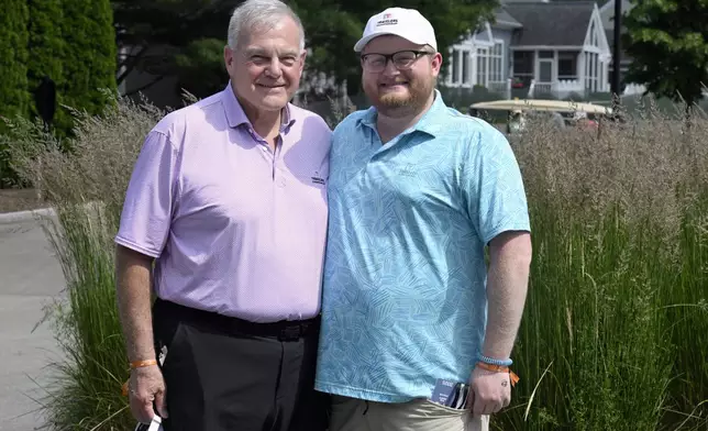 Andy Bessette, left, executive vice president and chief administrative officer for Travelers, and his son Chris Bessette, right, smile during the Travelers Championship golf tournament at TPC River Highlands in Cromwell, Conn., Thursday, June 19, 2025. (AP Photo/Jessica Hill)
