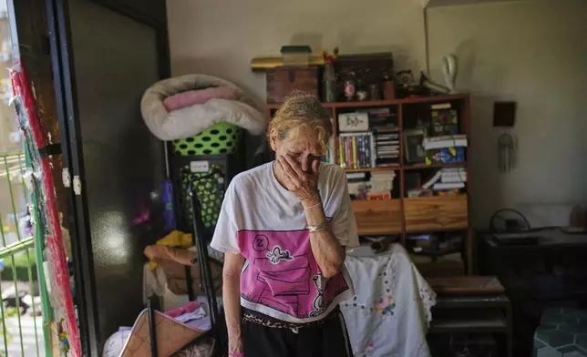 A local resident reacts inside her partially damaged house after a hit by a missile fired from Iran, in Holon, near Tel Aviv, Israel, Thursday, June 19, 2025. (AP Photo/Ohad Zwigenberg)