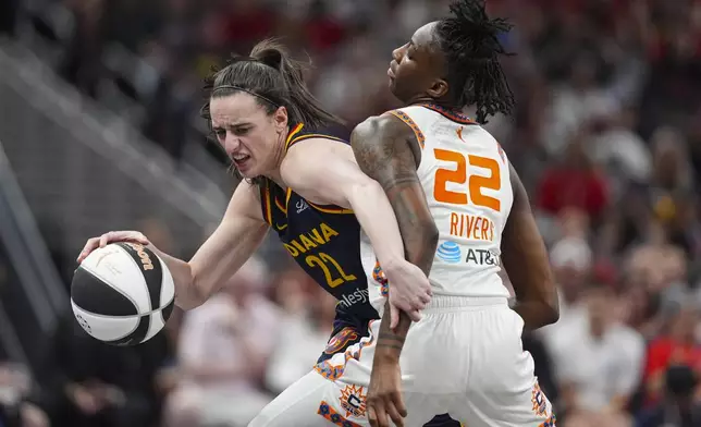 Indiana Fever guard Caitlin Clark (22) tries to get past Connecticut Sun guard Saniya Rivers (22) in the second half of a WNBA basketball game in Indianapolis, Tuesday, June 17, 2025. (AP Photo/Michael Conroy)