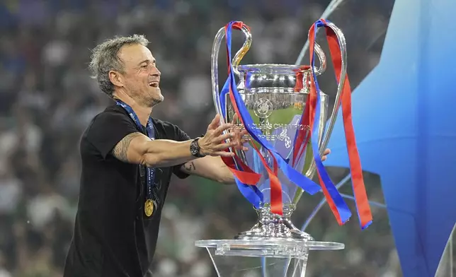 PSG's head coach Luis Enrique touches the trophy after winning the Champions League final soccer match against Inter Milan at the Allianz Arena in Munich, Germany, Saturday, May 31, 2025. (AP Photo/Martin Meissner)