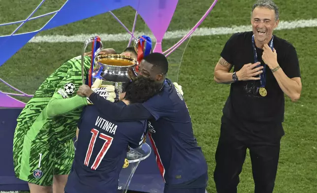 PSG's Gianluigi Donnarumma, Vitinha, Ousmane Dembele and coach Luis Enrique celebrate after winning the Champions League final soccer match between Paris Saint Germain and Inter Milan, at the Allianz Arena in Munich, Germany, Saturday, May 31, 2025. (Peter Kneffel/dpa via AP)