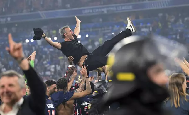 PSG's coach Luis Enrique is thrown into the air by his players as they celebrate winning the Champions League final soccer match between Paris Saint Germain and Inter Milan, at the Allianz Arena in Munich, Germany, Saturday, May 31, 2025. (Sven Hoppe/dpa via AP)