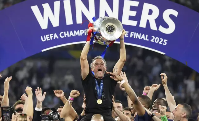 PSG's head coach Luis Enrique celebrates with the trophy after the Champions League final soccer match between Paris Saint-Germain and Inter Milan at the Allianz Arena in Munich, Germany, Saturday, May 31, 2025. (AP Photo/Matthias Schrader)