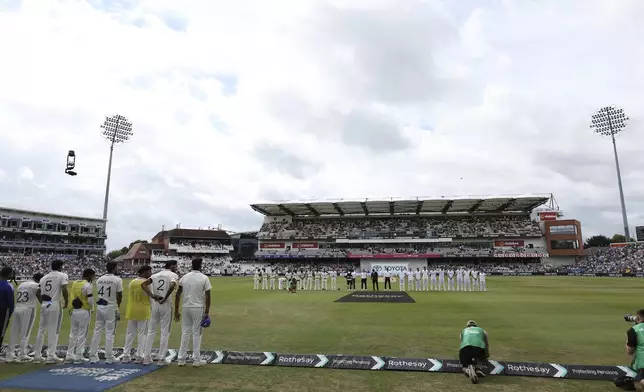 A general view of the the players from India and England as the mark a minute's applause for the passing of Dave Syd Lawrence ahead of day three of the first cricket test match between England and India at Headingley in Leeds, England, Sunday, June. 22, 2025. (AP Photo/Scott Heppell)