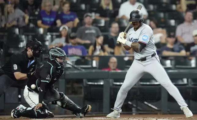 Arizona Diamondbacks catcher Jose Herrera, second from left, is unable to make a play on a wild pitch as Miami Marlins' Dane Myers, right, takes the ball while umpire Alex MacKay (9) looks on during the first inning of a baseball game Sunday, June 29, 2025, in Phoenix. (AP Photo/Ross D. Franklin)