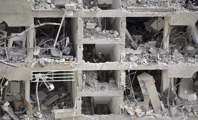 Israel's home front command officers survey the site of a direct missile strike launched from Iran in Tel Aviv, Israel, Sunday, June 22, 2025. (AP Photo/Oded Balilty)