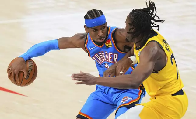 Indiana Pacers forward Aaron Nesmith, right, defends against Oklahoma City Thunder guard Shai Gilgeous-Alexander (2) during the second half of Game 2 of the NBA Finals basketball series Sunday, June 8, 2025, in Oklahoma City. (AP Photo/Kyle Phillips)
