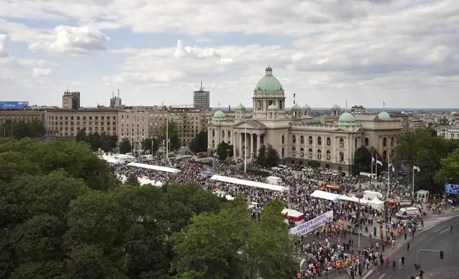 Government supporters hold a banner that reads "Blockaders - Remember - Serbia is not a genocidal state" outside the Parliament building ahead of a major anti-government rally pressing for an early election after nearly eight months of almost daily anti-corruption demonstrations that have shaken the populist government of President Aleksandar Vucic, in Belgrade, Serbia, Saturday, June 28, 2025. (AP Photo/Darko Vojinovic)
