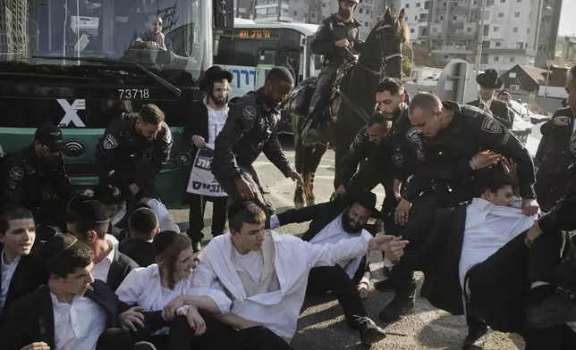 Israeli police officers disperse ultra-Orthodox Jewish men during a protest against army recruitment in Bnei Brak, Israel, Thursday, June 5, 2025. (AP Photo/Leo Correa)