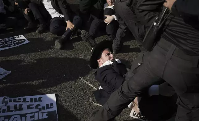 Israeli police officers disperse ultra-Orthodox Jewish men during a protest against army recruitment in Bnei Brak, Israel, Thursday, June 5, 2025. (AP Photo/Leo Correa)