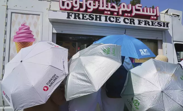Pilgrims crowd to buy ice cream to cool themselves at the rocky hill known as the Mountain of Mercy, on the Plain of Arafat, during the annual Hajj pilgrimage near the holy city of Mecca, Saudi Arabia, Thursday, June 5, 2025. (AP Photo/Amr Nabil)