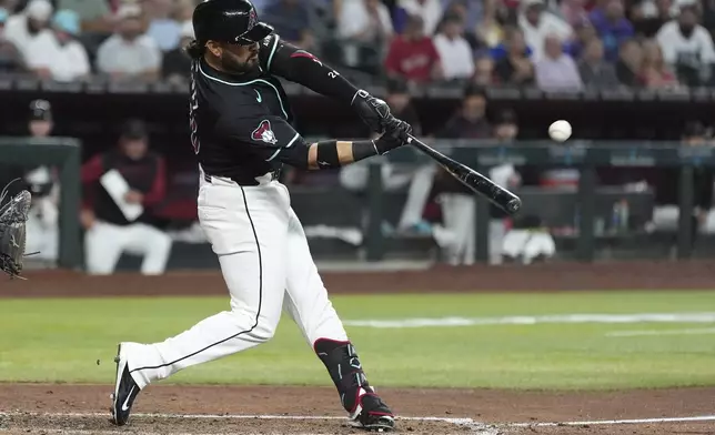 Arizona Diamondbacks' Eugenio Suárez connects for a grand slam against the Seattle Mariners during the sixth inning of a baseball game Wednesday, June 11, 2025, in Phoenix. (AP Photo/Ross D. Franklin)