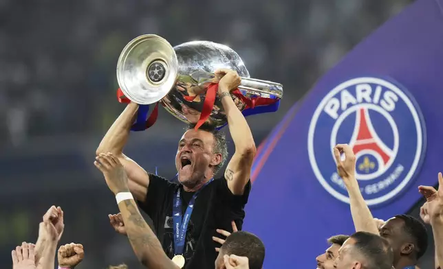 PSG's head coach Luis Enrique holds the trophy after winning the Champions League final soccer match between Paris Saint-Germain and Inter Milan at the Allianz Arena in Munich, Germany, Saturday, May 31, 2025. (AP Photo/Luca Bruno)