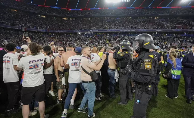 PSG fans invade the field at the end of the Champions League final soccer match between Paris Saint-Germain and Inter Milan at the Allianz Arena in Munich, Germany, Saturday, May 31, 2025. (AP Photo/Martin Meissner)
