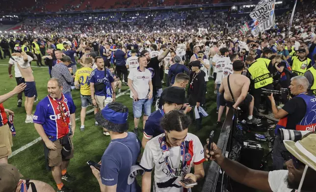 PSG fans raid the pitch after during the Champions League final soccer match between Paris Saint-Germain and Inter Milan at the Allianz Arena in Munich, Germany, Saturday, May 31, 2025. (AP Photo/Alexandra Beier)