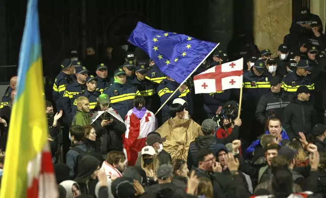 FILE - Police officers block demonstrators waving Georgian and EU flags during a rally to call for the release political prisoners and demand new elections in the center of Tbilisi, Georgia, Monday, March 31, 2025. (AP Photo/Zurab Tsertsvadze, File)