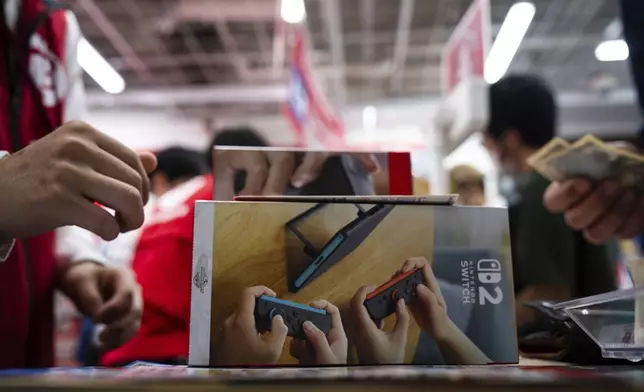 A customer purchases Nintendo Switch 2 at an electronics retailer in Tokyo, Thursday, June 5, 2025. (AP Photo/Louise Delmotte)
