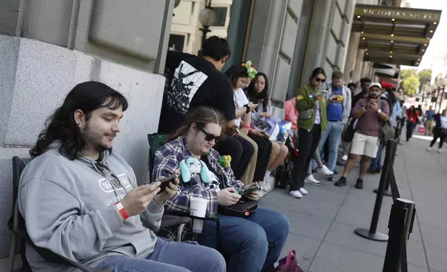 From left to right, Kenneth Knotts, of Danville and Ian Suelter-Davison, of Santa Cruz sit in chairs they brought to wait in line as they wait to enter the Nintendo Store for a pre-launch event for the Ninentdo Switch 2 on Wednesday, June 4, 2025, in San Francisco. (Lea Suzuki/San Francisco Chronicle via AP)