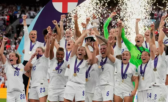 FILE - England's Leah Williamson, center left, and Millie Bright lift the trophy after winning the Women's Euro 2022 final soccer match between England and Germany at Wembley stadium in London, July 31, 2022. England won 2-1. (AP Photo/Alessandra Tarantino, File)