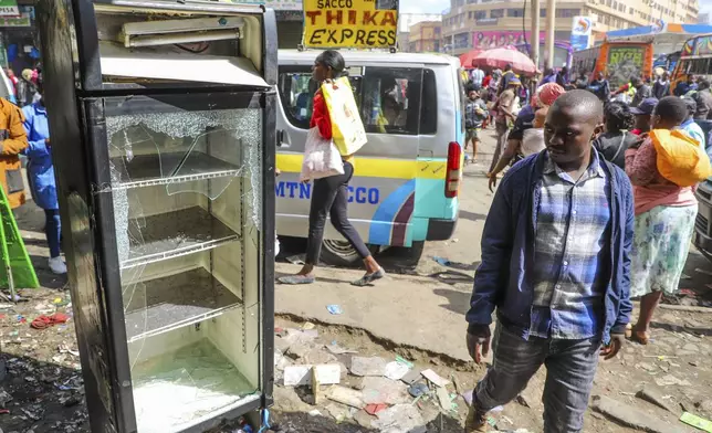 Business owners assess the damage to their vandalized merchandise and shop, following the one-year anniversary of deadly anti-tax demonstrations in Nairobi, Kenya, Thursday, June 26, 2025. (AP Photo/Patrick Ngugi)