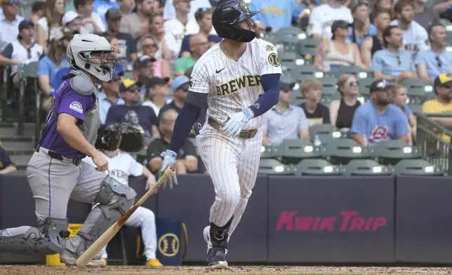 Milwaukee Brewers' Brice Turang hits an RBI double as Colorado Rockies catcher Braxton Fulford, left, looks on during the fifth inning of a baseball game Saturday, June 28, 2025, in Milwaukee. (AP Photo/Kayla Wolf)