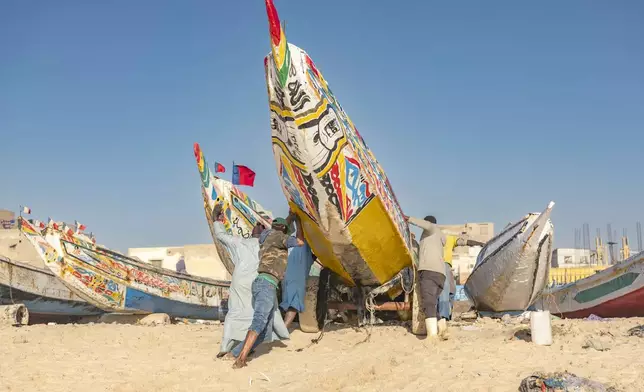 Fishermen park their pirogues after returning from fishing in Saint-Louis, Senegal, Thursday, March 13, 2025. (AP Photo/Sylvain Cherkaoui)