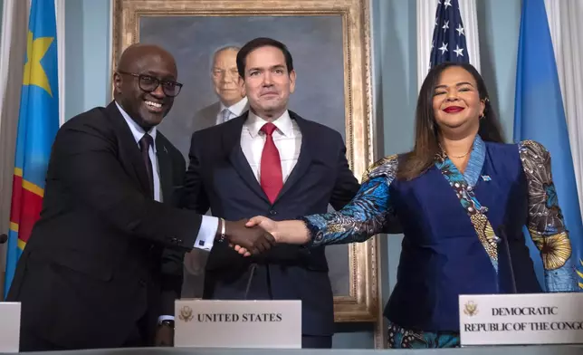 Secretary of State Marco Rubio, center, stands with Rwanda's Foreign Minister Olivier Nduhungirehe, left, and Democratic Republic of the Congo's Foreign Minister Therese Kayikwamba Wagner, right, as they shake hands after signing a peace agreement at the State Department, Friday, June 27, 2025, in Washington. (AP Photo/Mark Schiefelbein).