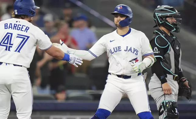 Toronto Blue Jays' Bo Bichette, right, celebrates his solo home run against the Arizona Diamondbacks with Addison Barger during the first inning of a baseball game in Toronto, Wednesday, June 18, 2025. (Frank Gunn/The Canadian Press via AP)