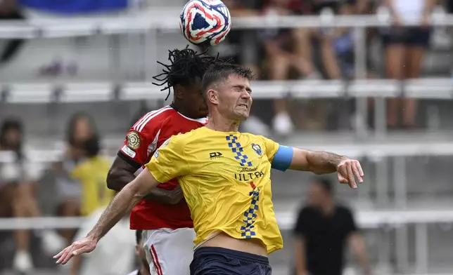 Auckland City's Mario Ilich, foreground, and Benfica's Leandro Barreiro jump for the ball during the Club World Cup Group C soccer match between Benfica and Auckland City in Orlando, Fla., Friday, June 20, 2025. (AP Photo/Phelan Ebenhack)