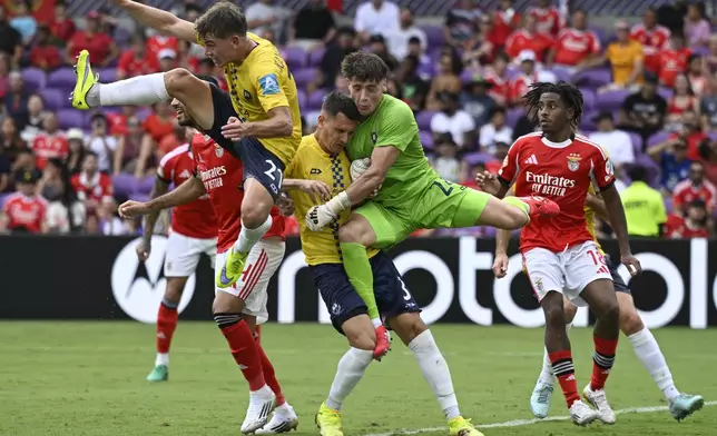 Auckland City's Adam Bell, left, Adam Mitchell, center, and Auckland City's Nathan Garrow try to save a ball during the Club World Cup Group C soccer match between Benfica and Auckland City in Orlando, Fla., Friday, June 20, 2025. (AP Photo/Phelan Ebenhack)