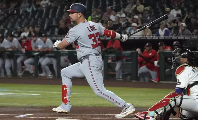 Washington Nationals' Nathaniel Lowe hits an RBI double against the Arizona Diamondbacks in the first inning during a baseball game, Saturday, May 31, 2025, in Phoenix. (AP Photo/Rick Scuteri)