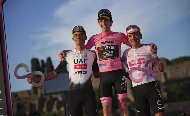 Britain's Simon Yates, winner of the Giro d'Italia cycling race, celebrates on the podium with second-placed Mexico's Isaac Del Toro, left, and third-placed Ecuador's Richard Carapaz, in Rome, Sunday, June 1, 2025. (AP Photo/Alessandra Tarantino)