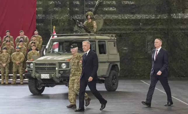Canada Prime Minister Mark Carney walks Chief of the Defence Staff, General Jennie Carignan and Minister of National Defence David McGuinty, right, as he prepares to make an announcement at Fort York Armoury in Toronto, Canada, on Monday, June 9, 2025. (Chris Young/The Canadian Press via AP)