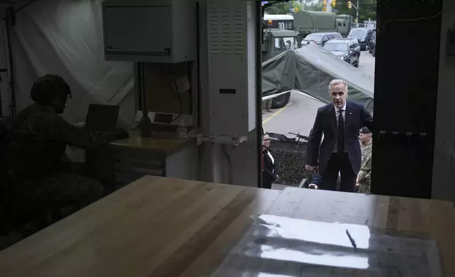 Canada Prime Minister Mark Carney steps into a command post as he visits Fort York Armoury in Toronto, Canada, before making an announcement on Monday, June 9, 2025. (Chris Young/The Canadian Press via AP)