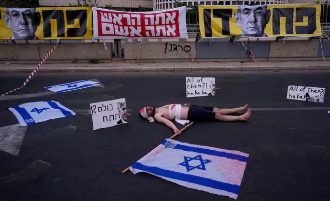 A demonstrator takes part in a performance during a protest demanding the end of the war and immediate release of hostages held by Hamas in the Gaza Strip, and against Prime Minister Benjamin Netanyahu's government in Tel Aviv, Saturday, May 31, 2025. (AP Photo/Ariel Schalit)