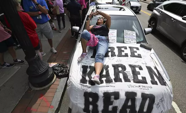 Dina Warchal, of Waltham, MA, a Karen Read supporter, listens to closing arguments of Read's trial from her car parked at the edge of the protest buffer zone around Norfolk Superior Court, Friday, June 13, 2025, in Dedham, Mass. (AP Photo/Josh Reynolds)