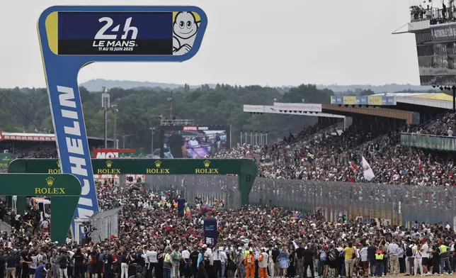 Spectators wait the start of the 24-hour Le Mans endurance auto race, Saturday June 14, 2025 in Le Mans, western France. (AP Photo/Jeremias Gonzalez)