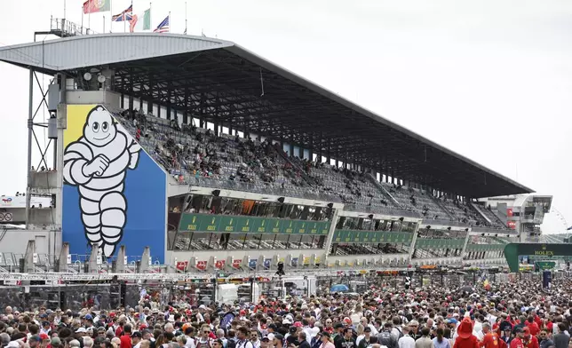 Spectators wait the start of the 24-hour Le Mans endurance auto race, Saturday June 14, 2025 in Le Mans, western France. (AP Photo/Jeremias Gonzalez)