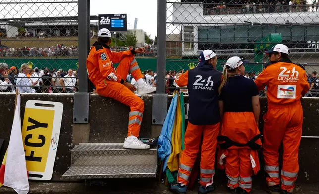 Technical staff wait for the start of the 24-hour Le Mans endurance auto race, in Le Mans, western France, Saturday, June 14, 2025 in Le Mans, western France. (AP Photo/Jeremias Gonzalez)