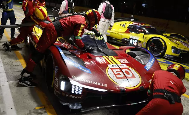 Pit crew members work on the No. 50, a Ferrari 499P with Antonio Fuoco of Italy, Miguel Molina of Spain and Nicklas Nielsen of Denmark during the 24-hour Le Mans endurance race, Sunday, June 15, 2025 in Le Mans, western France. (AP Photo/Jeremias Gonzalez)