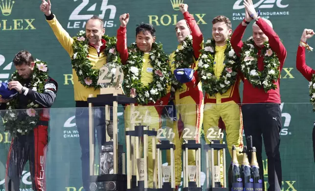AF Corse car a Ferrari 499P, Robert Kubica, center, Yifei Ye, center left, and Phil Hanson, center right, celebrate on the podium after winning the 24-hour Le Mans endurance race, Sunday June 15, 2025 in Le Mans, western France. (AP Photo/Jeremias Gonzalez)