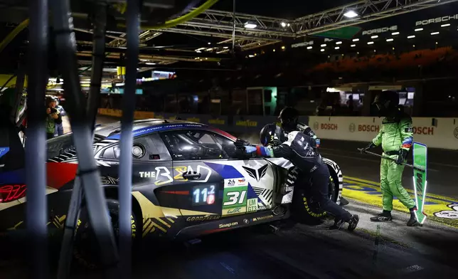 Crew members work on the No 31 car, a BMW M4 LMGT3 of THE BEND TEAM WRT during the 24-hour Le Mans endurance race, Sunday, June 15, 2025 in Le Mans, western France. (AP Photo/Jeremias Gonzalez)