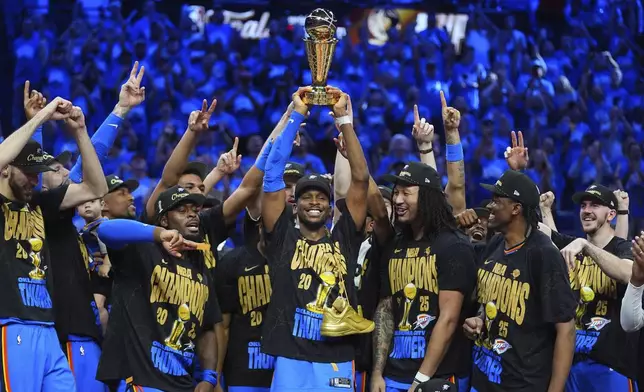 Oklahoma City Thunder guard Shai Gilgeous-Alexander, center, holds up the MVP trophy as he celebrates with his team after they won the NBA basketball championship with a Game 7 victory against the Indiana Pacers Sunday, June 22, 2025, in Oklahoma City. (AP Photo/Julio Cortez)