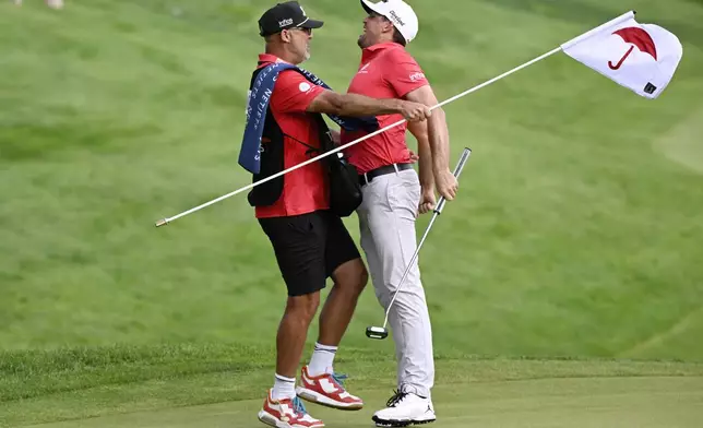 Keegan Bradley, right, chest bumps his caddie Scott Vail, left, in celebration after winning of the Travelers Championship golf tournament at TPC River Highlands, Sunday, June 22, 2025, in Cromwell, Conn. (AP Photo/Jessica Hill)