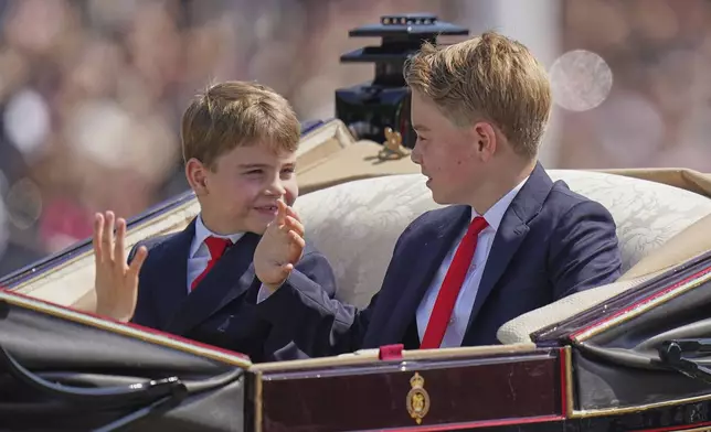 Prince George, right, and Prince Louis, children of Prince William and Kate, Princess of Wales, look at each other as they ride in a carriage to tale part in the Trooping the Colour in London, Saturday, June 14, 2025. (AP Photo/Alberto Pezzali)