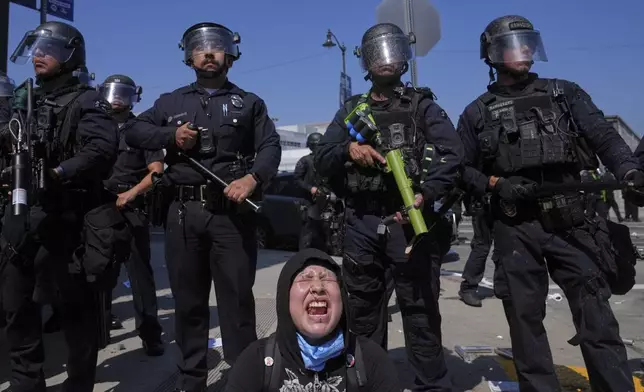 Maribel Parra screams as protesters confront a line of police near the metropolitan detention center of downtown Los Angeles, Sunday, June 8, 2025, following last night's immigration raid protest. (AP Photo/Jae Hong)